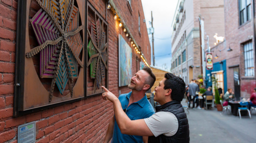 Two smiling men looking at art in the streets of Bend, Oregon.