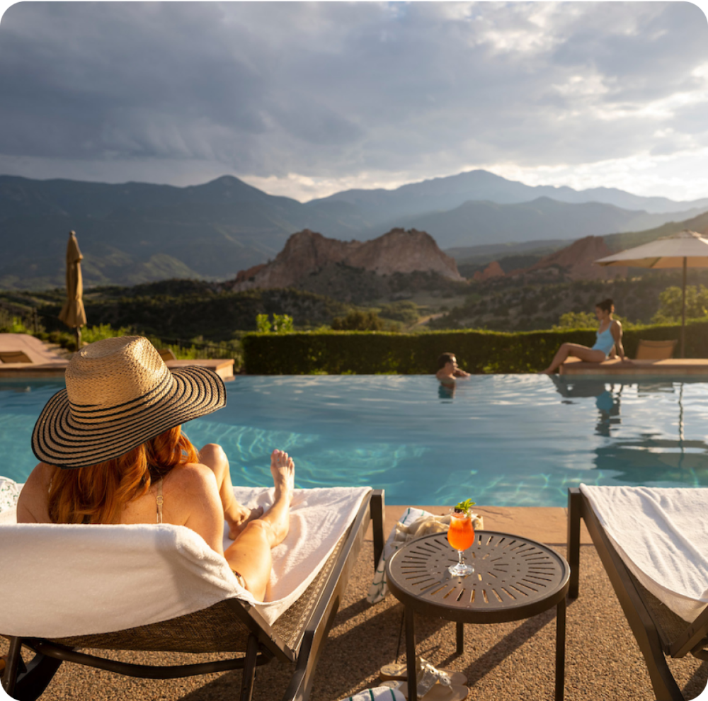 A woman sitting poolside at the Garden of Gods swimming pool.